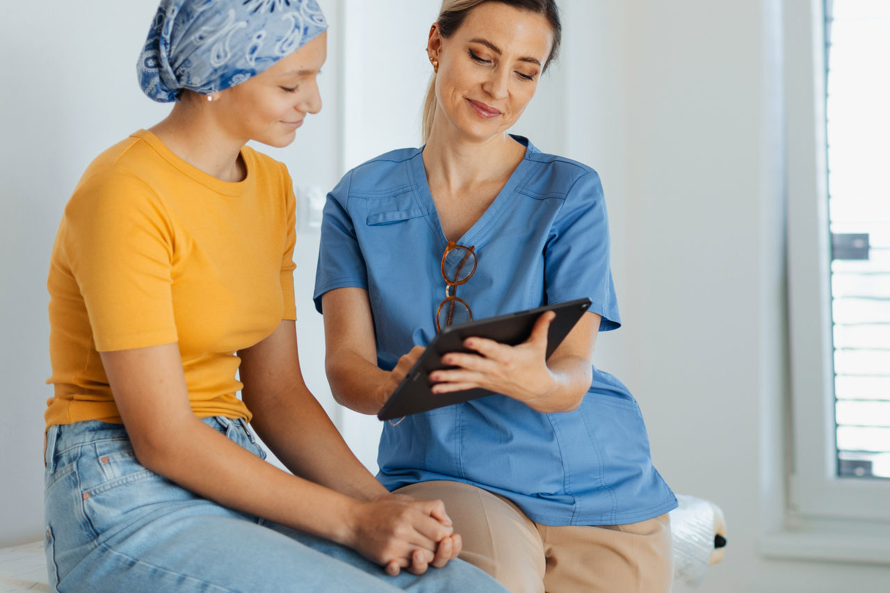 Teen with nurse reviewing iPad